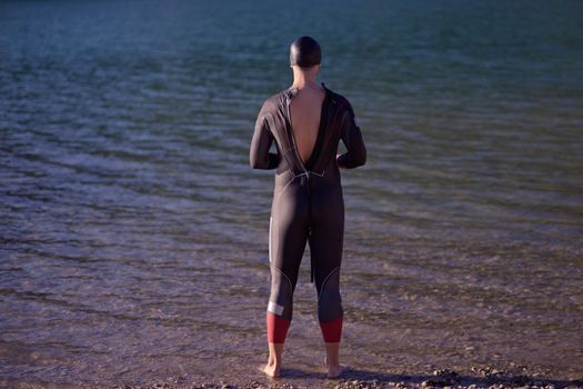 authentic triathlete swimmer portrait wearing wetsuit on morning  training