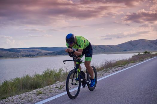 triathlon athlete riding professional racing bike at workout on curvy country road