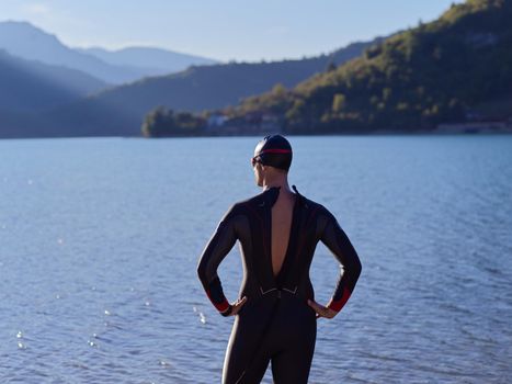 authentic triathlete swimmer portrait wearing wetsuit on morning  training