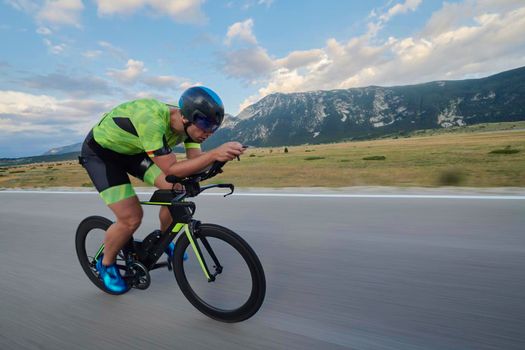 triathlon athlete riding professional racing bike at workout on curvy country road