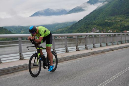 triathlon athlete riding racing bike on morning training urban enviroment