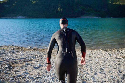 triathlon athlete start swimming training splashing water while running and jumping