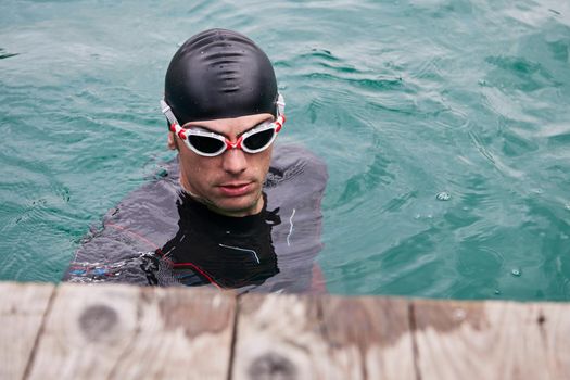 authentic triathlete swimmer portrait wearing wetsuit on morning  training