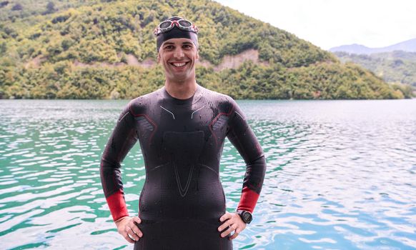 authentic triathlete swimmer portrait wearing wetsuit on morning  training