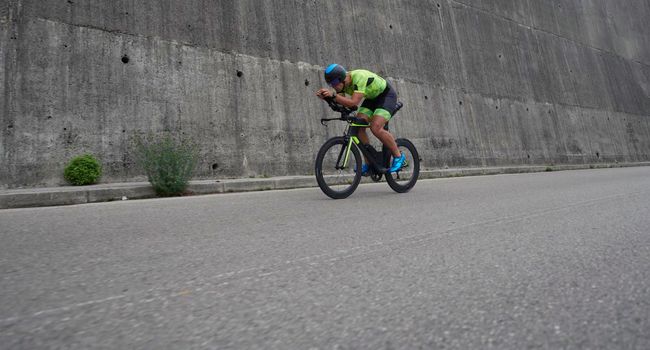 triathlon athlete riding racing bike on morning training urban enviroment