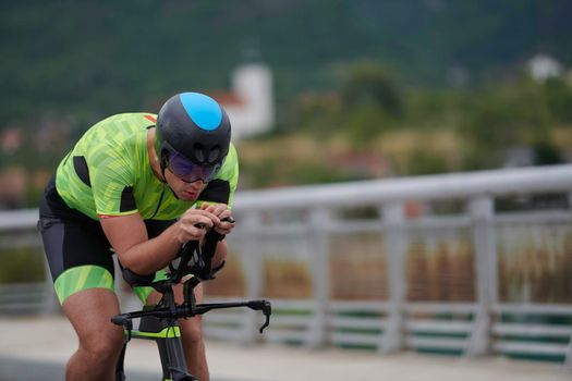 triathlon athlete riding racing bike on morning training urban enviroment