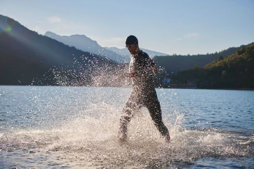 triathlon athlete start swimming training splashing water while running and jumping