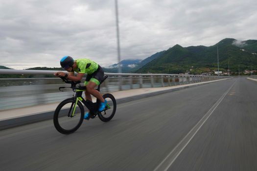 triathlon athlete riding racing bike on morning training urban enviroment