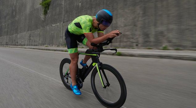 triathlon athlete riding racing bike on morning training urban enviroment