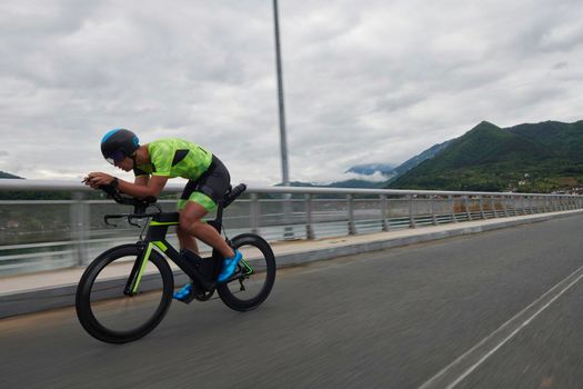 triathlon athlete riding racing bike on morning training urban enviroment