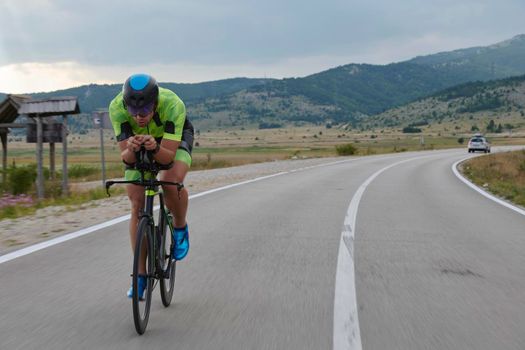 triathlon athlete riding professional racing bike at workout on curvy country road