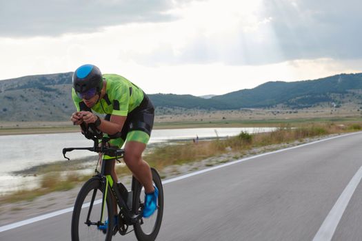 triathlon athlete riding professional racing bike at workout on curvy country road