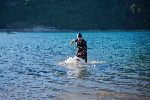 triathlon athlete start swimming training splashing water while running and jumping