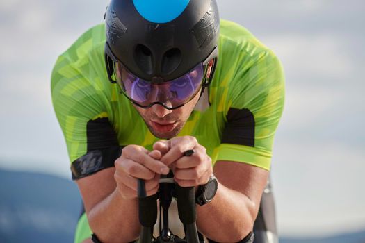 triathlon athlete riding professional racing bike at workout on curvy country road