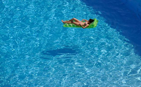 happy young woman relax at swimming pool at vacation travel resort 