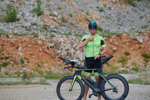 triathlon athlete riding professional racing bike at workout on curvy country road