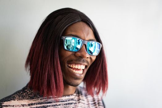 Funny black boy with long hair and sunglasses laughing