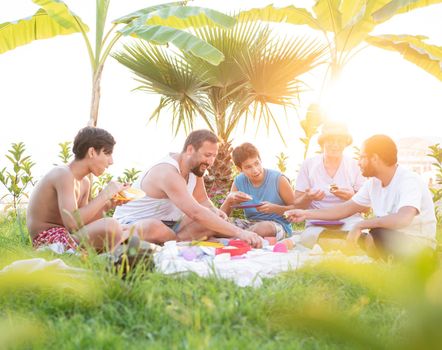 Happy family enjoying picnic on beach near sea