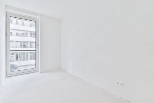 An absolutely white room with windows in an elegant apartment