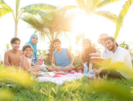 Happy family enjoying picnic on beach near sea