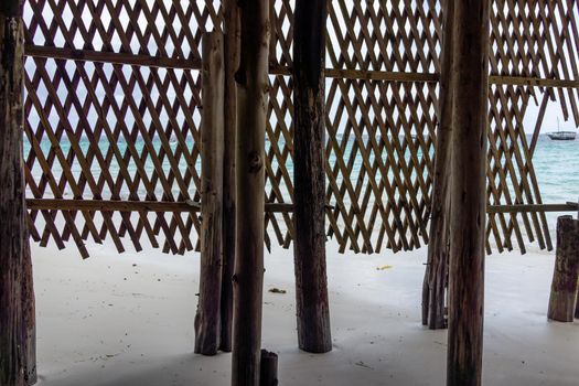 Wooden pillars on ocean shore into blue water with no people