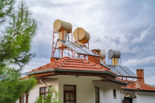 Concept saving electricity. Barrels of water heated by solar batteries installed on roof of house. Solar energy.