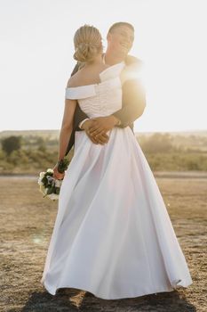 Portrait of a bride and groom in a sunset light close up
