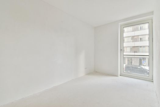 An absolutely white room with windows in an elegant apartment