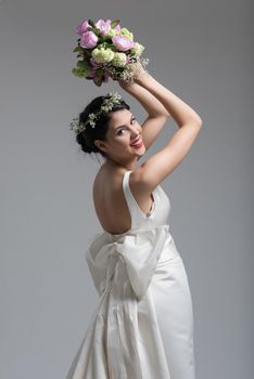 Young attractive bride with the a bouquet of flowers isolated on white background.