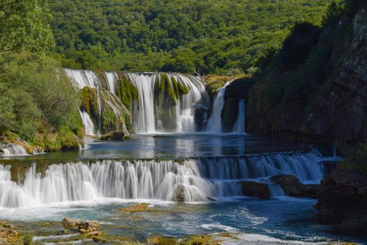 waterfall on wild river with fresh drinking water in summer