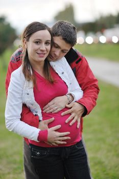 happy couple outdoor,  beautiful pregnant woman with her husband