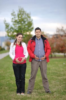 happy couple outdoor,  beautiful pregnant woman with her husband