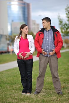 happy couple outdoor,  beautiful pregnant woman with her husband