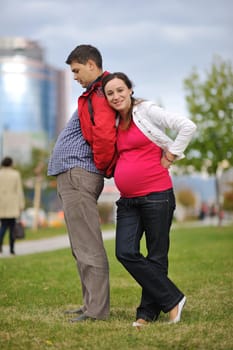 happy couple outdoor,  beautiful pregnant woman with her husband