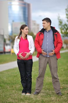 happy couple outdoor,  beautiful pregnant woman with her husband