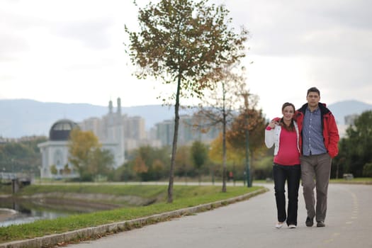 happy couple outdoor,  beautiful pregnant woman with her husband