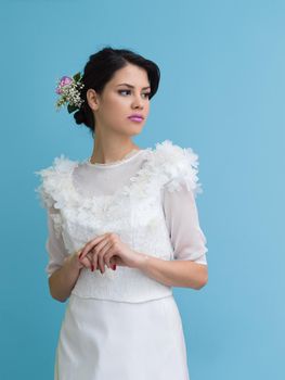 Portrait of beautiful young women in wedding dress isolated on a cyan background