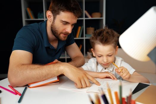 Father helping his little son with school homework close up
