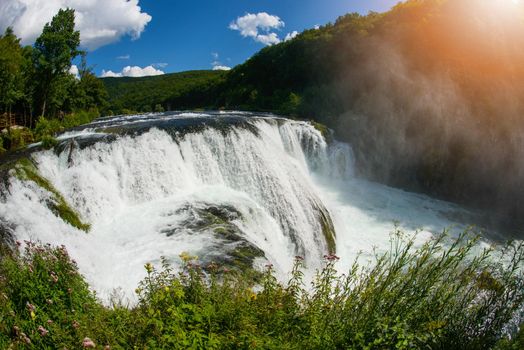 waterfall in beautiful nature with crystal clear water on wild river una in bosnia and herzegovina at sunny summer day