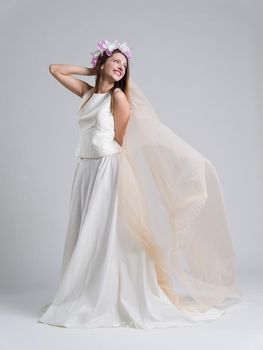 Portrait of beautiful young bride in a wedding dress with a veil isolated on a white background