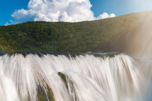 waterfall in beautiful nature with crystal clear water on wild river una in bosnia and herzegovina at sunny summer day