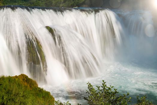 waterfall in beautiful nature with crystal clear water on wild river una in bosnia and herzegovina at sunny summer day