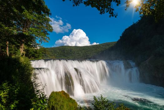 waterfall in beautiful nature with crystal clear water on wild river una in bosnia and herzegovina at sunny summer day
