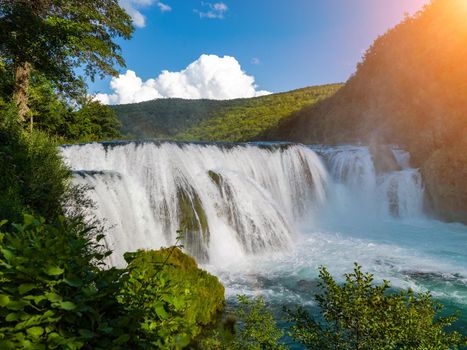 waterfall in beautiful nature with crystal clear water on wild river una in bosnia and herzegovina at sunny summer day