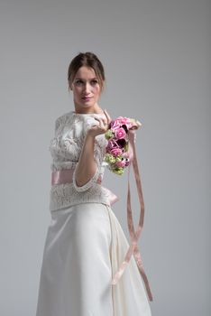 Young attractive bride with the a bouquet of flowers isolated on white background.