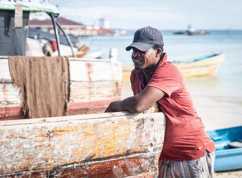 Candid black fisherman on coast ocean