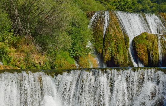 waterfall on wild river with fresh drinking water in summer