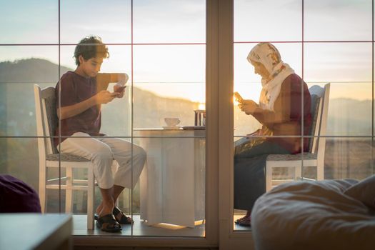 Mother and son enjoying drinking tea on the balcony