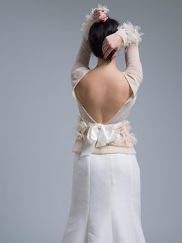 Rear view of a beautiful young bride in a wedding dress isolated on a white background