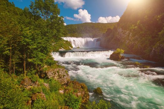 waterfall in beautiful nature with crystal clear water on wild river una in bosnia and herzegovina at sunny summer day